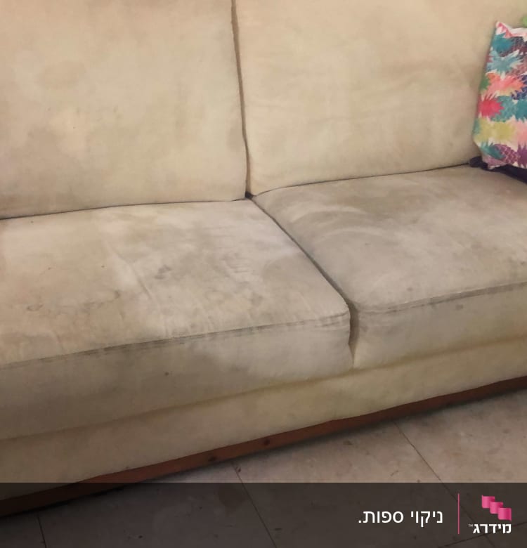 ספה מלוכלכת עם כתמים כהים על הריפוד